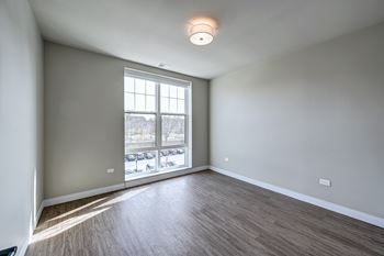 A room with a large window and wooden flooring.